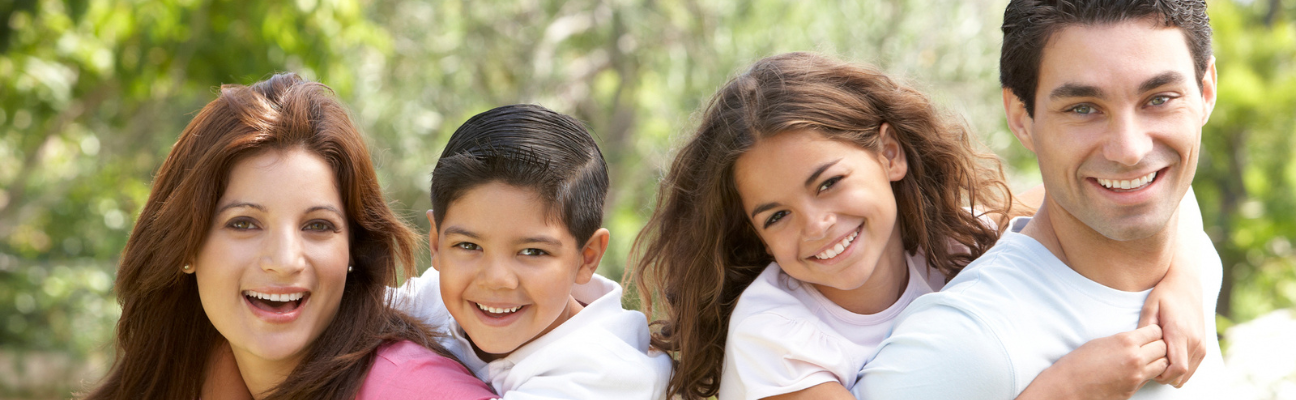 Mother and Father with children on their back smiling